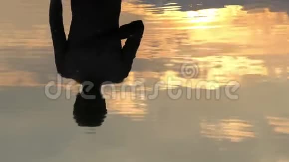 斯洛莫夕阳湖中一个年轻人竖起大拇指的倒影视频的预览图