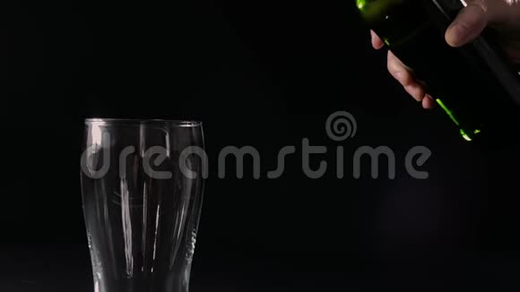 把啤酒从绿色瓶子里倒入玻璃杯中慢动作视频的预览图