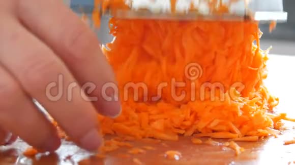 一大堆胡萝卜女人的手擦在磨碎的胡萝卜上视频的预览图