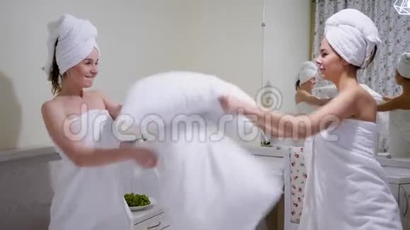 在浴巾里的女朋友聚会玩得开心在床上用枕头互相拍打视频的预览图