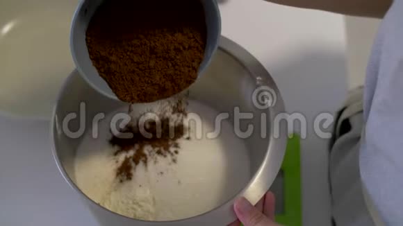 糕点厨师把可可倒入一碗面粉中视频的预览图
