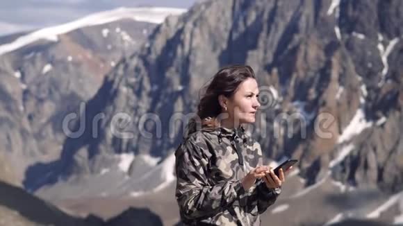 山背景上的年轻女子被拍照打电话打电话旅行者视频的预览图