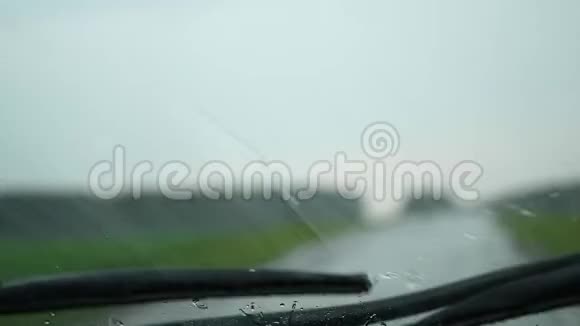 汽车在高速公路上行驶外面雨下得很大挡风玻璃雨刷在工作玻璃上的雨滴视频的预览图