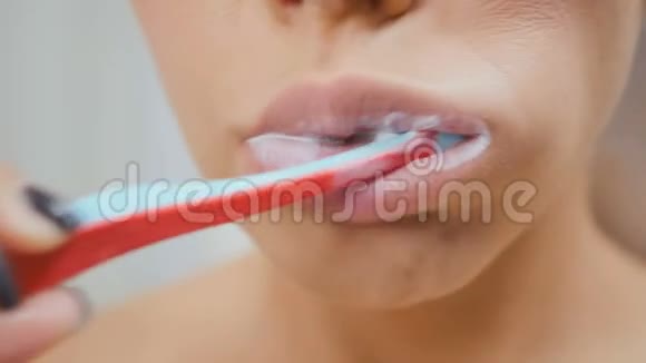 女人用牙膏和牙刷清洁牙齿视频的预览图