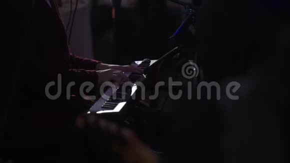 音乐家在黑暗的舞台上演奏键盘视频的预览图
