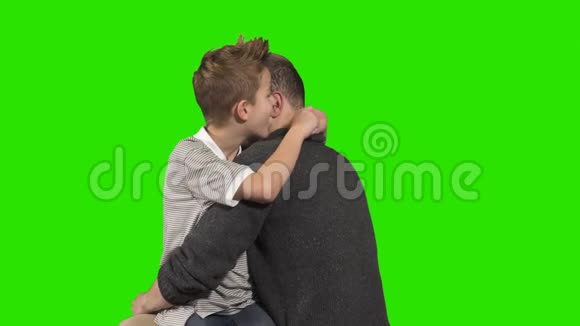小男孩在绿色的背景下在哥哥耳边低语秘密视频的预览图