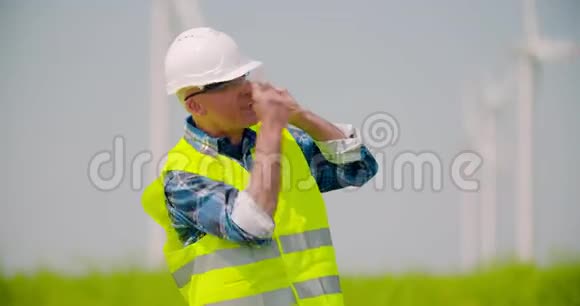 愤怒的工程师用手机对着风车农场说话视频的预览图