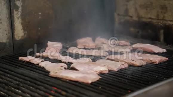 厨师在烤架上烤牛排火焰和红色余烬阿根廷烤架烧烤准备视频的预览图
