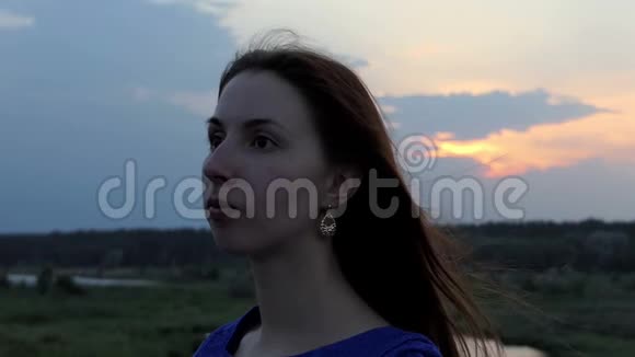 一个美丽的女人转过脸微笑着在斯洛文尼亚的湖岸上视频的预览图