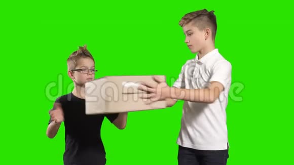 两个男孩在绿色背景上互相递盒子视频的预览图