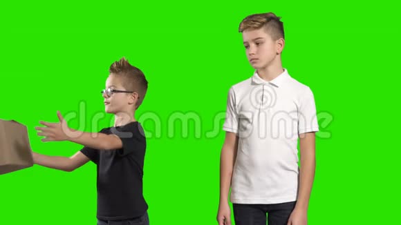两个男孩在绿色背景上互相递盒子视频的预览图