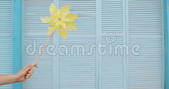 黄色风车在蓝色甲板背景上随风旋转夏季概念视频的预览图