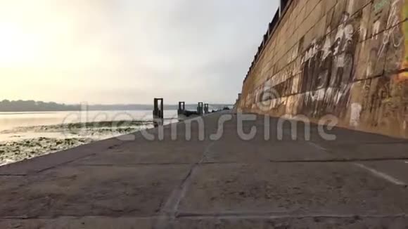 青年运动员在日落时分沿着德尼普罗河岸快速奔跑视频的预览图