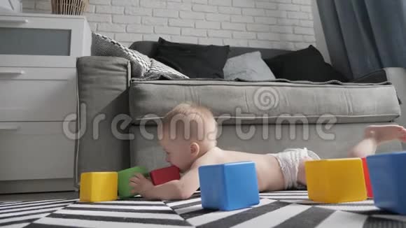 小男孩在地板上的房间里玩五颜六色的小积木孩子玩彩色游戏视频的预览图