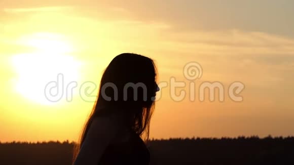 在日落时慢动作的女孩剪影视频的预览图