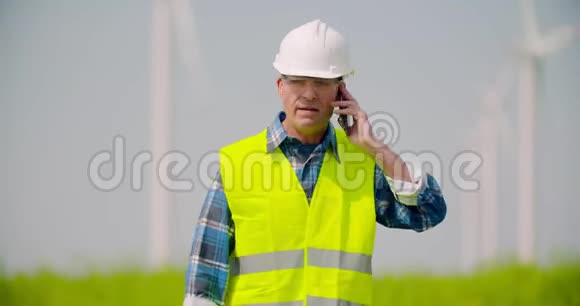 愤怒的工程师在手机上谈论风车农场视频的预览图
