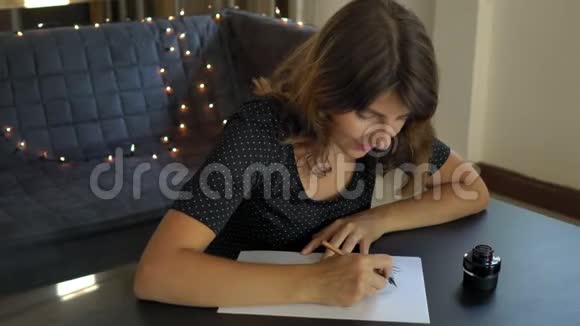 一位年轻女子用刻字技巧在纸上书写书法的特写镜头她写着梦想远大的目标视频的预览图