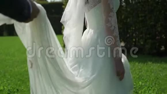 阳光明媚的夏日新郎新娘穿过公园视频的预览图
