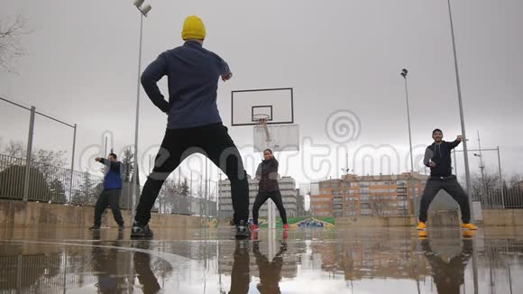 街头训练多民族青年体育团体在户外篮球上打太极拳视频的预览图