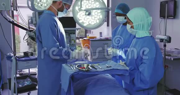 高加索外科医生在手术室做手术的侧视图视频的预览图