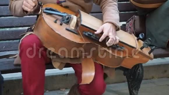 街头音乐家身着古老的东方民族服饰演奏传统中东乐器的音乐视频的预览图