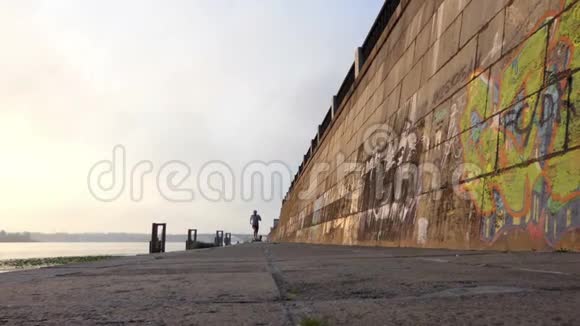 年轻的金发男人在斯隆莫的日落时分沿着德尼伯河岸快速奔跑视频的预览图