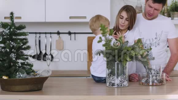 家人爸爸妈妈和儿子在厨房的桌子上玩圣诞内饰视频的预览图