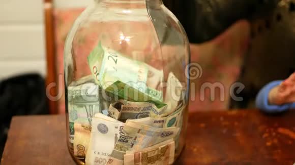 手女孩把纸钱放在玻璃罐里节省了概念视频的预览图