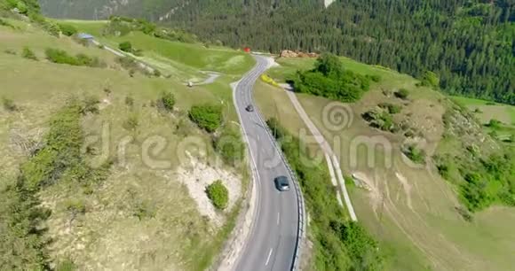 在山谷4k以上的山区道路上的汽车和自行车交通的鸟瞰图乘搭过山城的绕道而过视频的预览图