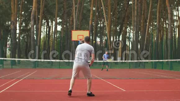 积极运动的男子在硬场上打网球视频的预览图