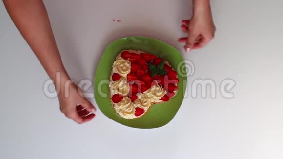 这位女士在盘子里放了一个现成的馅饼涂上奶油用草莓和柠檬香膏装饰视频的预览图