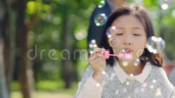 在公园里吹泡泡的亚洲小女孩视频的预览图