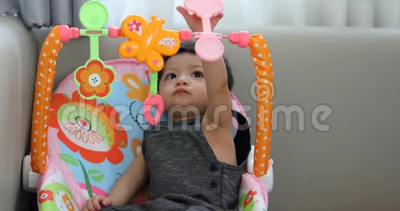 可爱的小男孩用手指在头顶上玩五颜六色的玩具视频的预览图