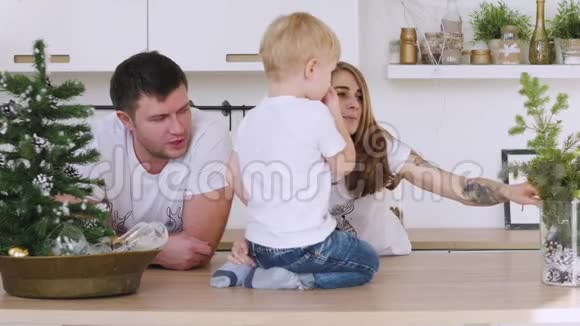 家人爸爸妈妈和儿子在厨房的桌子上玩圣诞内饰视频的预览图