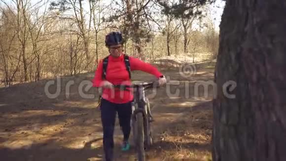 年轻的白种人女运动员骑自行车的人用手工具工具一个自行车泵把空气充气到轮胎轮山视频的预览图