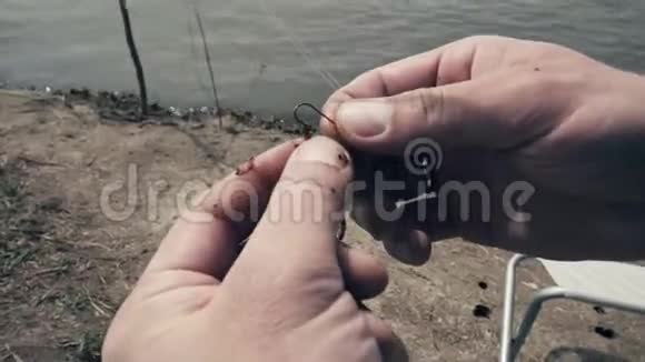 垂钓者鱼钩上的鱼钩虫特写鱼钩上的蚯蚓视频的预览图