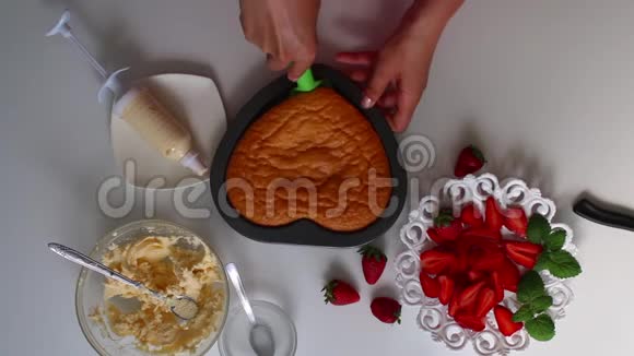 女人从烤盘里拿饼干茶托旁边是一个草莓有一个奶油视频的预览图