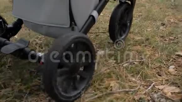 婴儿车在森林道路上行驶车轮的特写视频的预览图