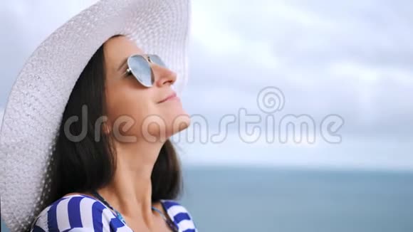 特写照片微笑美丽的女游客戴着帽子和太阳镜放松和享受视频的预览图