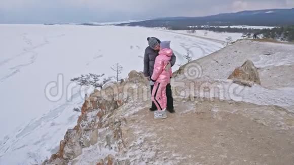 这对年轻夫妇喜欢在冬天的山顶上户外散步活跃的情侣走过冬天美丽视频的预览图