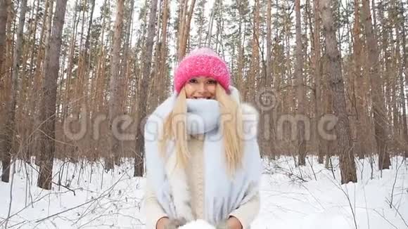 在冬天的森林里一个年轻的女人微笑着把雪抛起视频的预览图