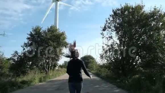 快乐的女孩跑到风车涡轮慢莫视频的预览图