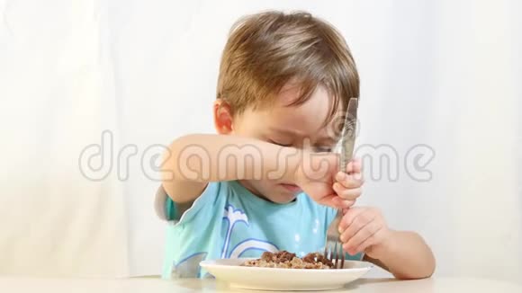 小男孩用盘子里的叉子吃食物视频的预览图