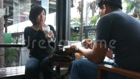 泰国男人和女人坐着放松在咖啡厅喝冰咖啡聊天视频的预览图