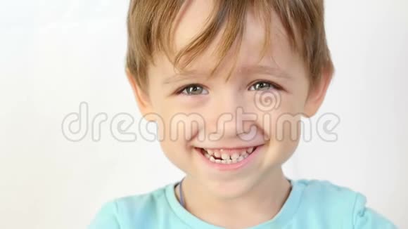 一个孩子喜笑颜开的特写镜头看着镜头双手抱在脑后捂住耳朵视频的预览图