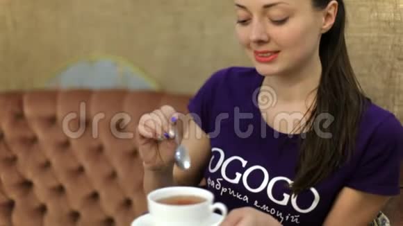一个女孩正在喝白色杯子里的茶视频的预览图