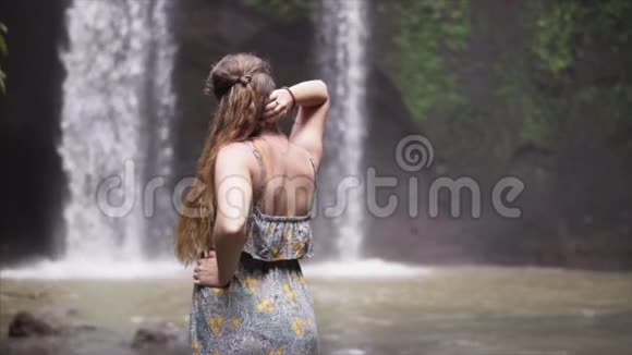 户外留着健康长发的美女幸福的年轻女子享受着狂野的自然和瀑布的力量美丽美丽视频的预览图