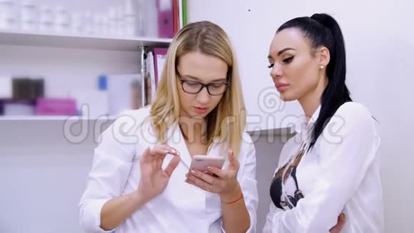 美容室两个年轻漂亮的女人一个医生和一个病人讨论各种美容程序看看视频的预览图