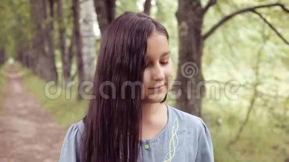 肖像在阳光明媚的日子里一个甜美美丽的小女孩闻着一束鲜花站在大自然上微笑着视频的预览图