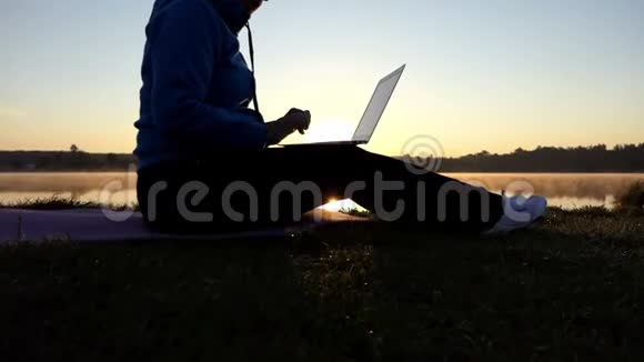 创意女性在日落时分在电脑上输入一个短篇小说视频的预览图
